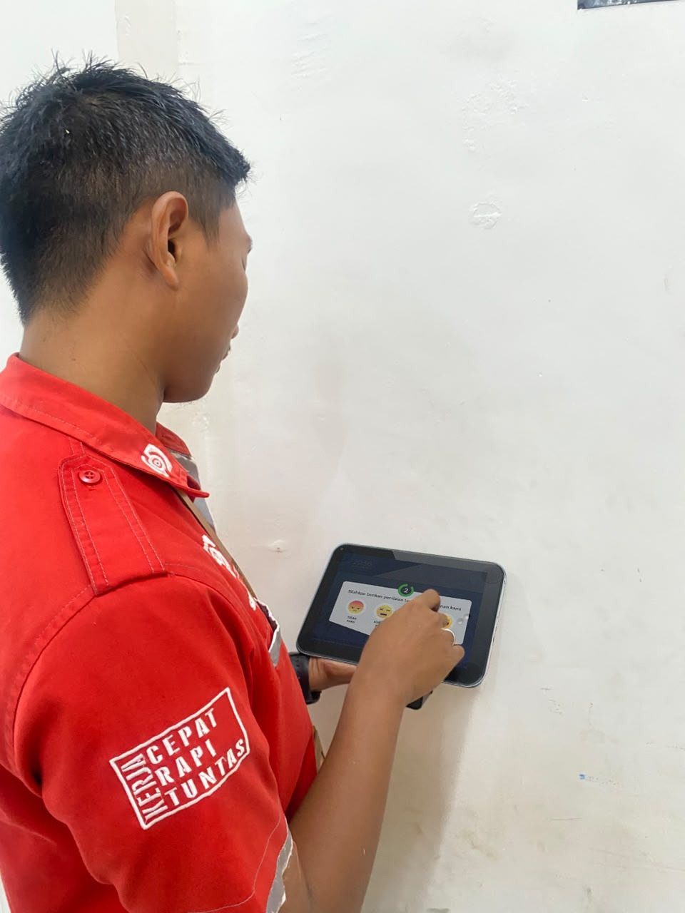 Instalasi SmartSanitasi — Pengujian tablet oleh teknisi setelah pemasangan di dinding